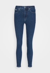 Tmavě modré skinny džíny vyrobené z denimu. Obsahují zapínání na knoflík, dvě přední kapsy a hladkou, rovnoměrnou strukturu.