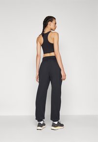 New Balance WARMING PERFORMANCE JOGGER - Donji dijelovi trenirke - black