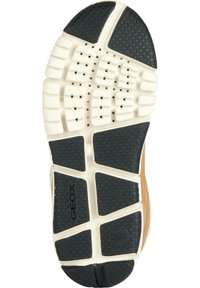 Suela de una zapatilla beige y negra con la marca Geox y agujeros de ventilación para transpirabilidad.