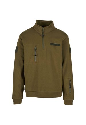 Tamsiai žalia fleece tipo pūstas su ketvirčio užtrauktuku, dviem užtrauktuku uždaromomis kišenėmis ir viena užsegama kišene su velcro krūtinėje ir ant rankovės.