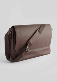 Brun læder messenger taske med en struktureret overflade, en bred flap og en justerbar rem. Har et elegant, rektangulært design.