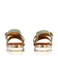 Grüne Ledersandalen mit einem breiten Riemendesign und einem goldenen Akzent an der Ferse sowie einer weißen Gummisohle, die einen geschichteten Look zeigen.