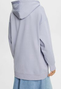 Sudadera de color púrpura claro con cremallera trasera, puños y dobladillo acanalados, y una capucha acogedora. La textura suave de la tela mejora la comodidad y calidez.