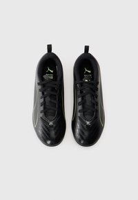 Scarpe da calcio nere con una tomaia testurizzata, caratterizzate da una finitura liscia e dettagli verde. Stringhe e un'etichetta sul tallone per una vestibilità facile.