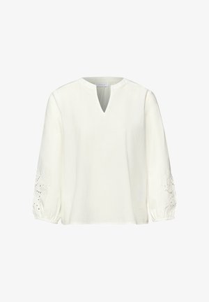 Biała bluzka z długim rękawem, dekoltem w kształcie litery V z wycięciem oraz elastycznymi mankietami, zdobiona kwiatowymi koronkowymi wycięciami na rękawach.