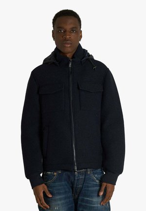 Giacca con cappuccio color blu navy con chiusura a zip, due tasche frontali e finitura testurizzata. Presenta polsini elastici e collo foderato.