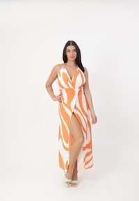 Maxi kjole med orange og hvide bølgedesign, halterneck, dyb udskæring og en slidse til låret for ekstra flair.