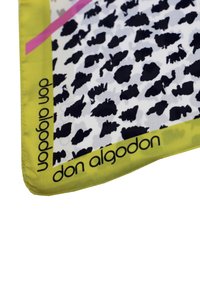 Bufanda de seda con un patrón de estampado animal en blanco y negro, con un borde amarillo vibrante y la marca "don algodon" a lo largo del borde.