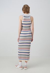 Vestido maxi a rayas con textura de canalé, que presenta líneas horizontales en verde, rojo, azul y blanco. La vista desde atrás muestra un diseño ajustado.