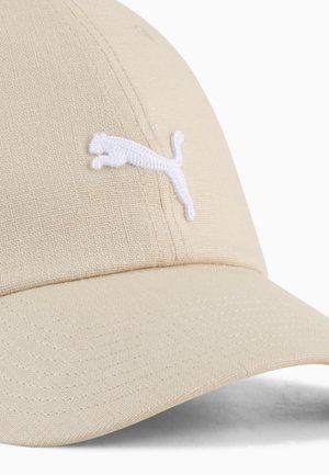 Beige pet met een gebogen klep, gemaakt van gestructureerde stof. Voorzien van een wit geborduurd Puma-logo aan de voorkant.