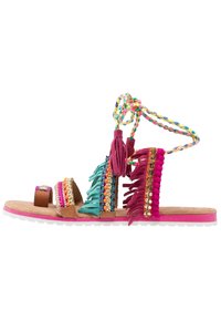Sandales à franges avec des pompons multicolores, des accents en perles et des brides tressées. Bord en cuir marron et semelle rose. Chaussures décontractées d'été.