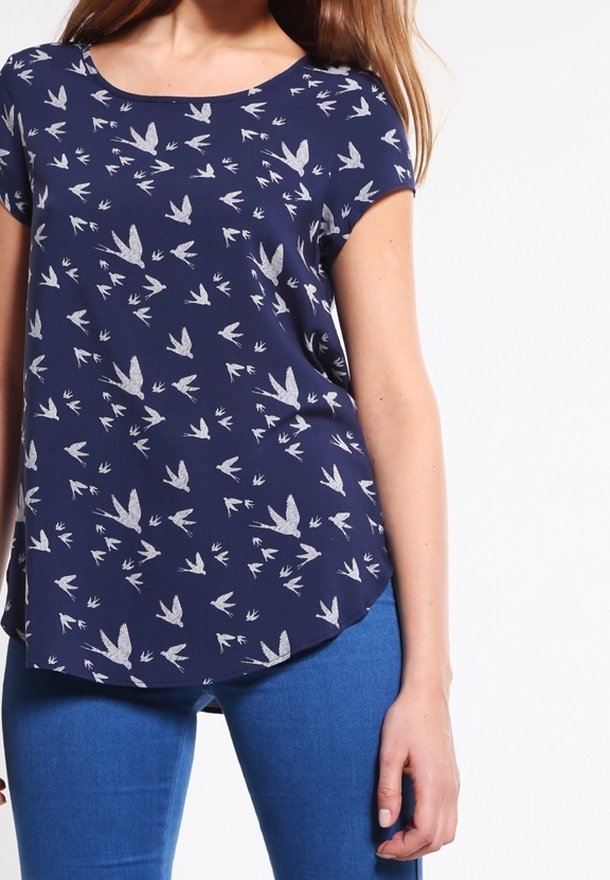 Námořnická blůza s krátkým rukávem a kulatým výstřihem, zdobená bílým vzorem ptáků. Materiál má hladkou texturu; horní lem je mírně zaoblený.