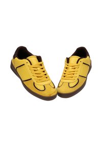 Zapatillas amarillas con parte superior de cuero suave, detalles en marrón, cierre de cordones y suela de goma con diseño de punta redondeada.