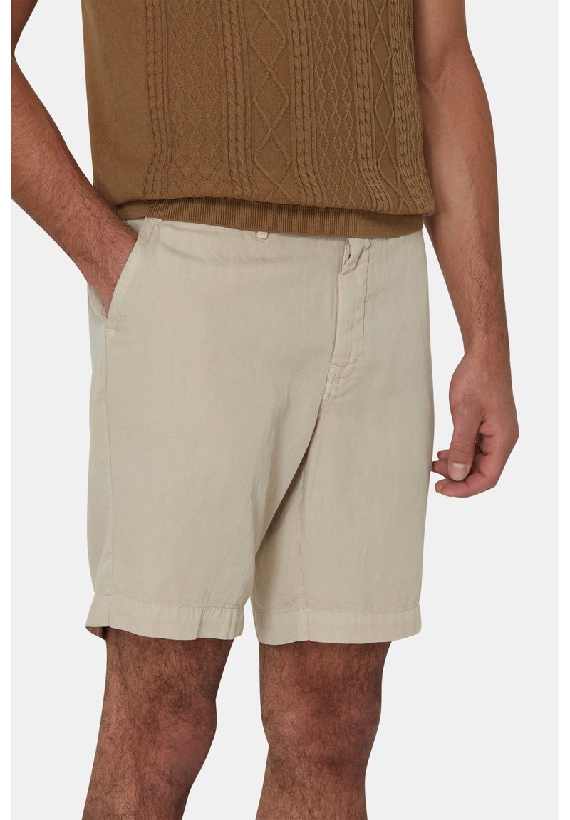 Pantaloni corti in lino beige con tasche laterali, chiusura frontale con bottone e orlo leggermente arrotolato. Il tessuto ha una consistenza liscia e leggera.