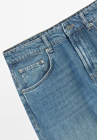 Jeans in denim azzurro chiaro con un classico design a cinque tasche, chiusura con bottone e zip, cuciture visibili e una texture leggermente sbiadita.