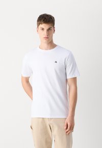Hvid kortærmet t-shirt i bomuld med rund halsudskæring og et lille sort logo på venstre bryst. Enkel og klassisk design.