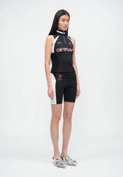 Černý sportovní top s vysokým límcem a zipem, doplněný černobílými šortkami. Obsahuje branding Off-White a slim fit. Stříbrná obuv.