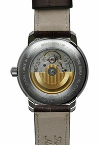 Automatic watch with silver stainless steel case, transparent case back, gold-toned movement, and brown leather strap. 3 ATM water-resistant.