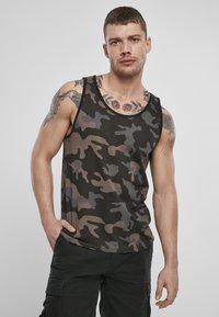Top de camuflaj în nuanțe de negru, gri și maro, având o croială lejeră, cu brâuri largi pentru brațe și o textură fină din bumbac. Accentuate cu un decolteu rotund.