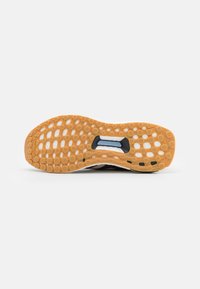 Semelle de chaussure avec motif en nid d'abeille et étiquette "TORSION SYSTEM" dans la zone médio-pied, avec une semelle extérieure en caoutchouc Continental.