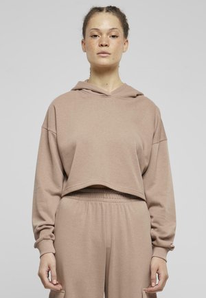Sweatshirt court couleur marron clair avec capuche, manches longues et poignets élastiques, associé à un pantalon taille haute assorti. Tissu doux et texturé.