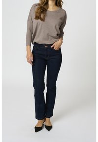 Brown knit sweater with three-quarter sleeves, paired with dark blue straight-leg jeans and black pointed-toe heels. Simple design, casual fit.