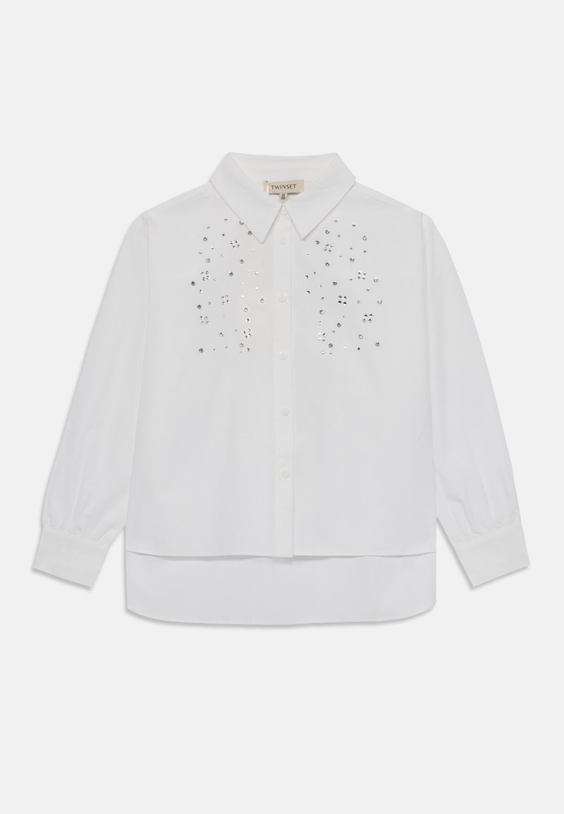 White button-up shirt with long sleeves, featuring a subtle sequin pattern on the front and a rounded hem. Made from a lightweight fabric.