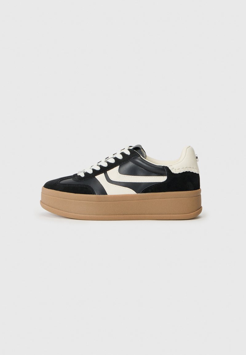 Czarno-kremowe sneakersy z zamszowej i skórzanej cholewki, z grubą gumową podeszwą i okrągłymi sznurowadłami, ozdobione logo po boku.