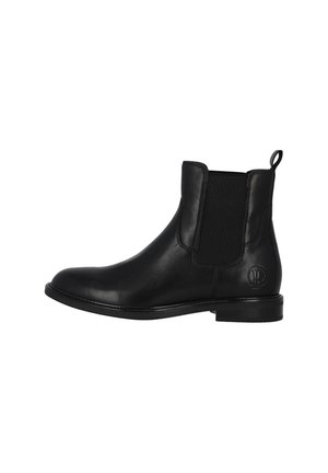 Botas Chelsea de cuero negro con paneles laterales elásticos, puntera redonda y tirador. Acabado suave y detalles de costura a lo largo de la suela.