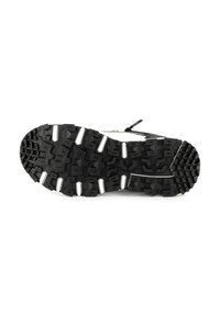 Suola di scarpa sportiva nera con un motivo testurizzato robusto, caratterizzata da accenti bianchi e un bordo rinforzato per stabilità e grip.