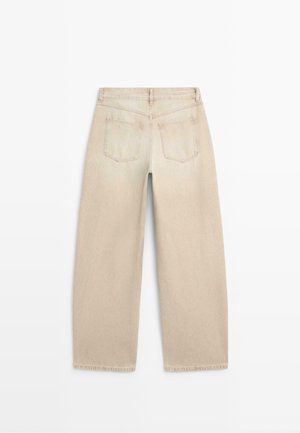 Jeans beige a gamba larga mostrati da dietro, con due tasche posteriori, passanti per cintura e dettagli di cuciture visibili.