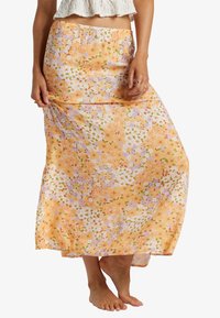Falda maxi floral en color naranja, con un material ligero y fluido que presenta una mezcla de pequeñas flores moradas, verdes y rosas. Cintura elástica.