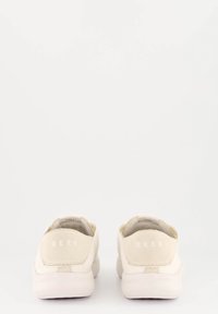 Helle beigefarbene Schuhe mit einem glatten Obermaterial aus Canvas, runder Form und weicher Gummisohle. Das "REEF"-Logo ist auf der Ferse eingeprägt.