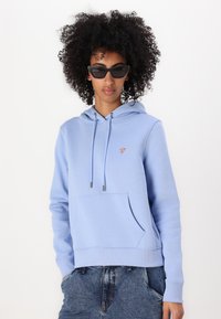 Ανοιχτό μπλε φούτερ από μαλακό υλικό, με μπροστινή τσέπη, κουκούλα με κορδόνια, ribbed μανίκια και μια μικρή ετικέτα λογότυπου στο στήθος.