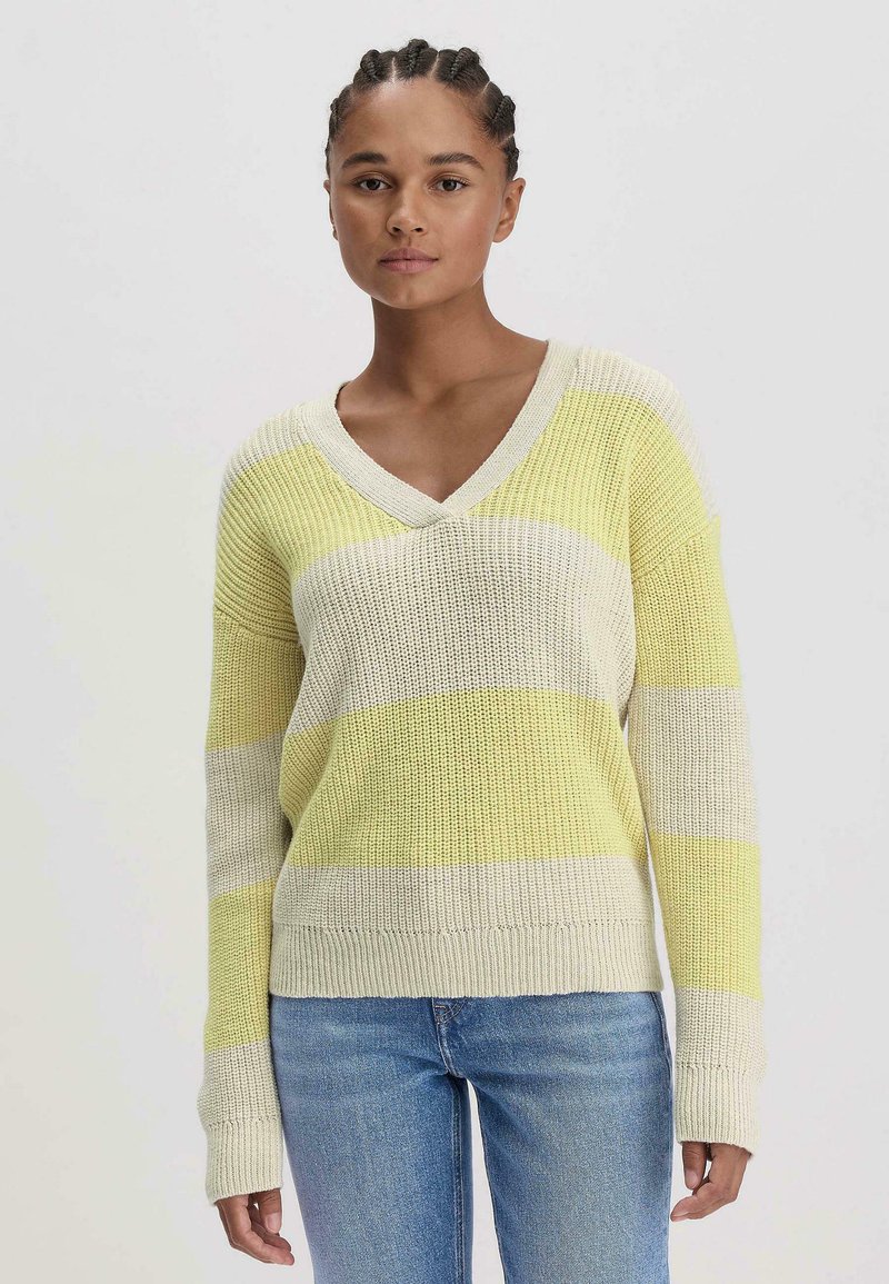 Strickpullover mit V-Ausschnitt, der horizontale gelbe und beige Streifen aufweist. Lange, lockere Ärmel und gerippte Saumdetails.
