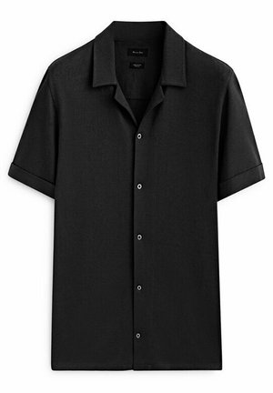 Chemise noire à manches courtes avec boutons, col camp et manches retroussées, présentée à plat sur fond blanc.