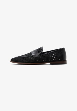 Zwarte geperforeerde lederen loafer met een pennybandje en een bruine zool, zijaanzicht op een witte achtergrond.