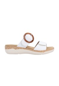 White sandal with two straps, featuring a large brown circular accent. Rubber sole with a textured pattern in tan. Lightweight design.