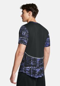 T-shirt de sport à manches courtes avec un corps noir et un motif abstrait violet. Dispose d'un col rond et d'accents réfléchissants le long des coutures.