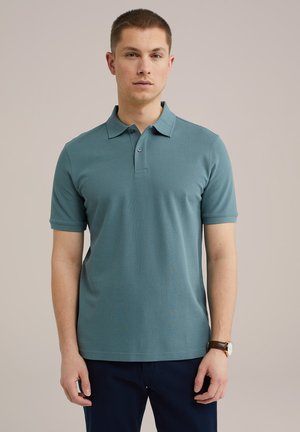 Polo shirt scurt de culoare teal, cu guler și închidere cu trei butoane. Textură netedă, design ajustat, asortat cu pantaloni închiși la culoare.