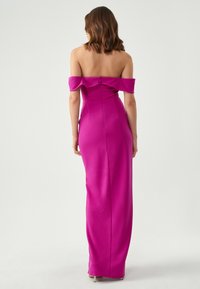 Fuchsiová off-shoulder večerní šaty se skinny designem a dlouhou sukní. Obsahuje volánkový výstřih a zadní zip.