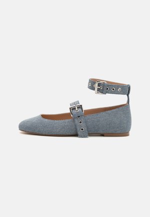 Chaussure plate en denim bleu avec un bout rond, deux sangles à boucle réglables sur le cou-de-pied et la cheville, et semelle beige.
