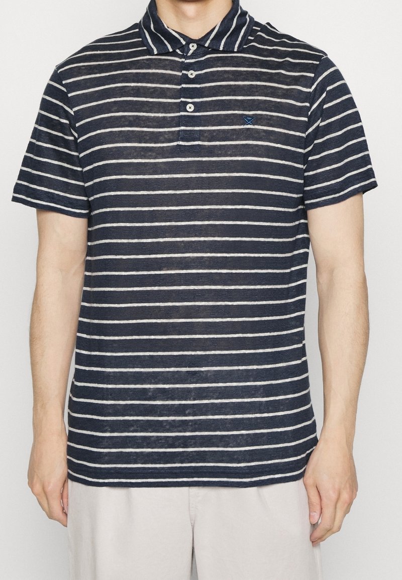 Polo a rayas marino hecho de tejido ligero, con cuello, tapeta de tres botones y un pequeño logotipo bordado en el pecho.