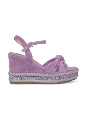 Le sandali con tacco a cuneo in suede viola presentano un cinturino alla caviglia, un design anteriore annodato e dettagli luccicanti decorativi attorno alla suola.