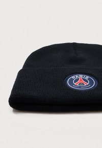 Fekete kötött sapka, hajtott szélekkel. Díszítve egy hímzett kör alakú logóval, melyen "PARIS" és "SAINT-GERMAIN" feliratok találhatók kék, piros és arany színekben.