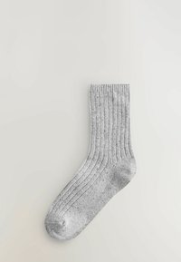 Hallide triibuline sokk, mis on valmistatud tekstuuriga kangast, omab pehmet ja venivast materjalist varrast ning tugevdatud varbaosa vastupidavuse tagamiseks.