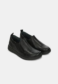 Scarpe slip-on in pelle nera con pannelli elasticizzati ai lati, punta arrotondata e suola in gomma testurizzata per aderenza e comfort.