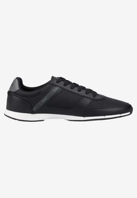 Baskets basses noires avec lacets noirs, semelle blanche et accents gris, arborant la marque "Lacoste" sur le côté et la languette du talon.