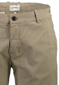 Pantalones beige con patrón y una tela texturizada y perforada. Presentan un cierre de botón y una etiqueta en la cintura que dice "Lindbergh".