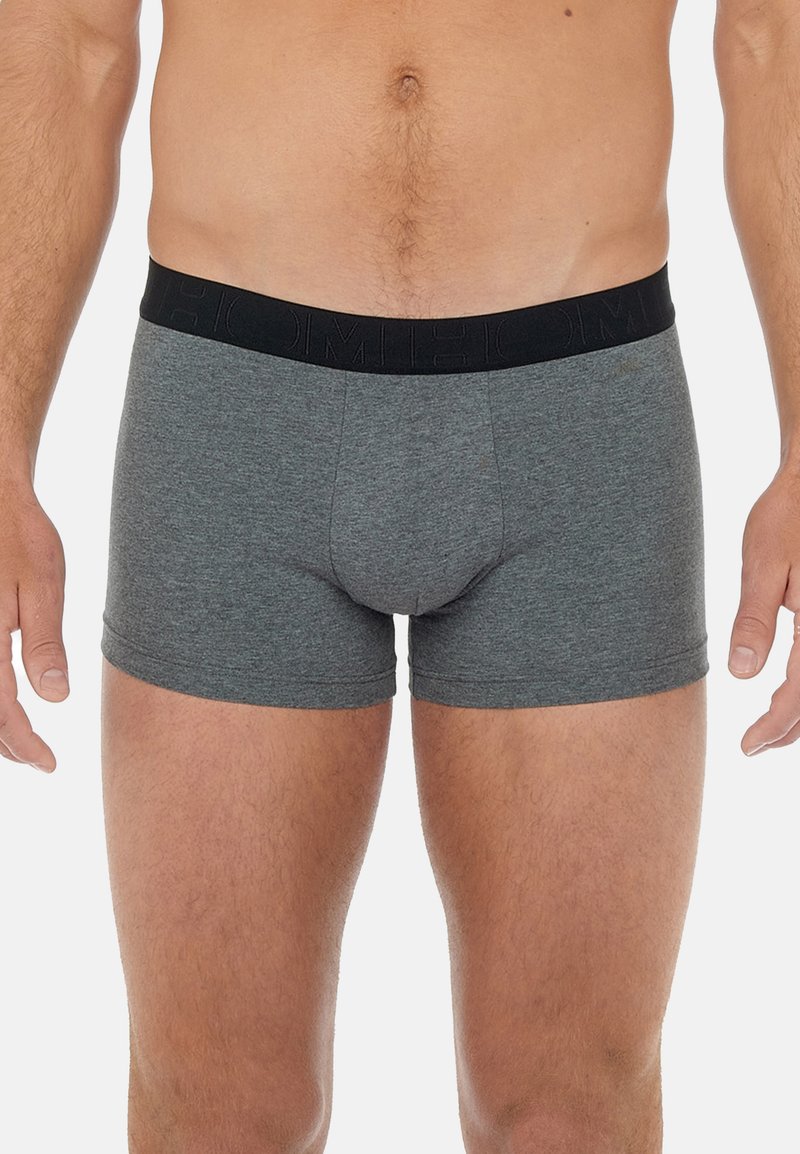 Gray cotton boxer shorts with a black elastic waistband featuring embossed logo detail. Fitted design, mid-thigh length, smooth texture.